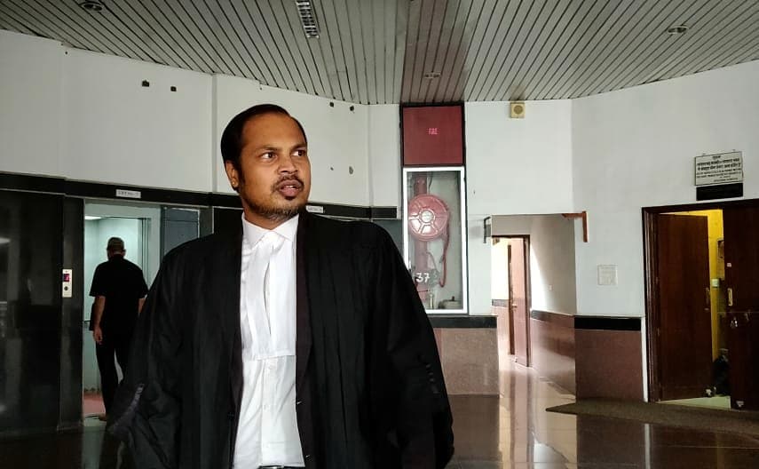 An advocate in gown and bands walking through a corridor