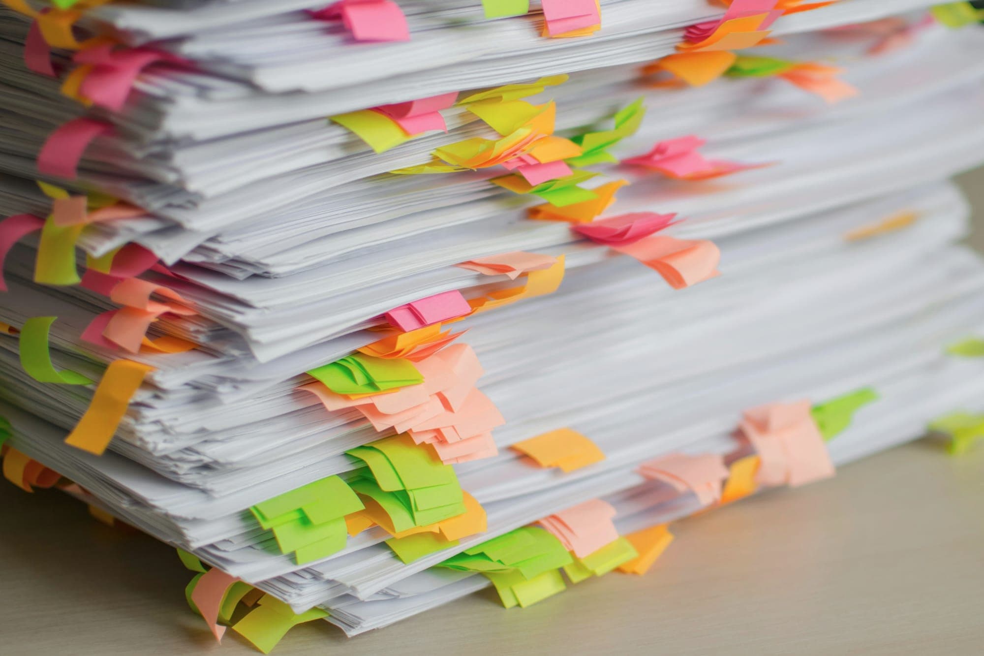 A stack of papers marked with coloured sticky tabs