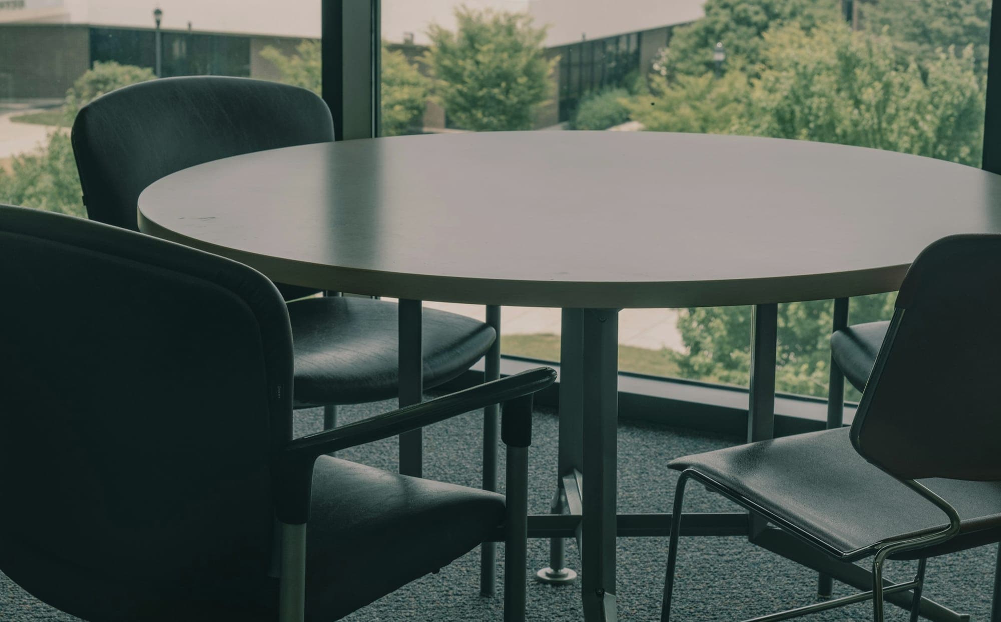 A round table and chairs before a large window