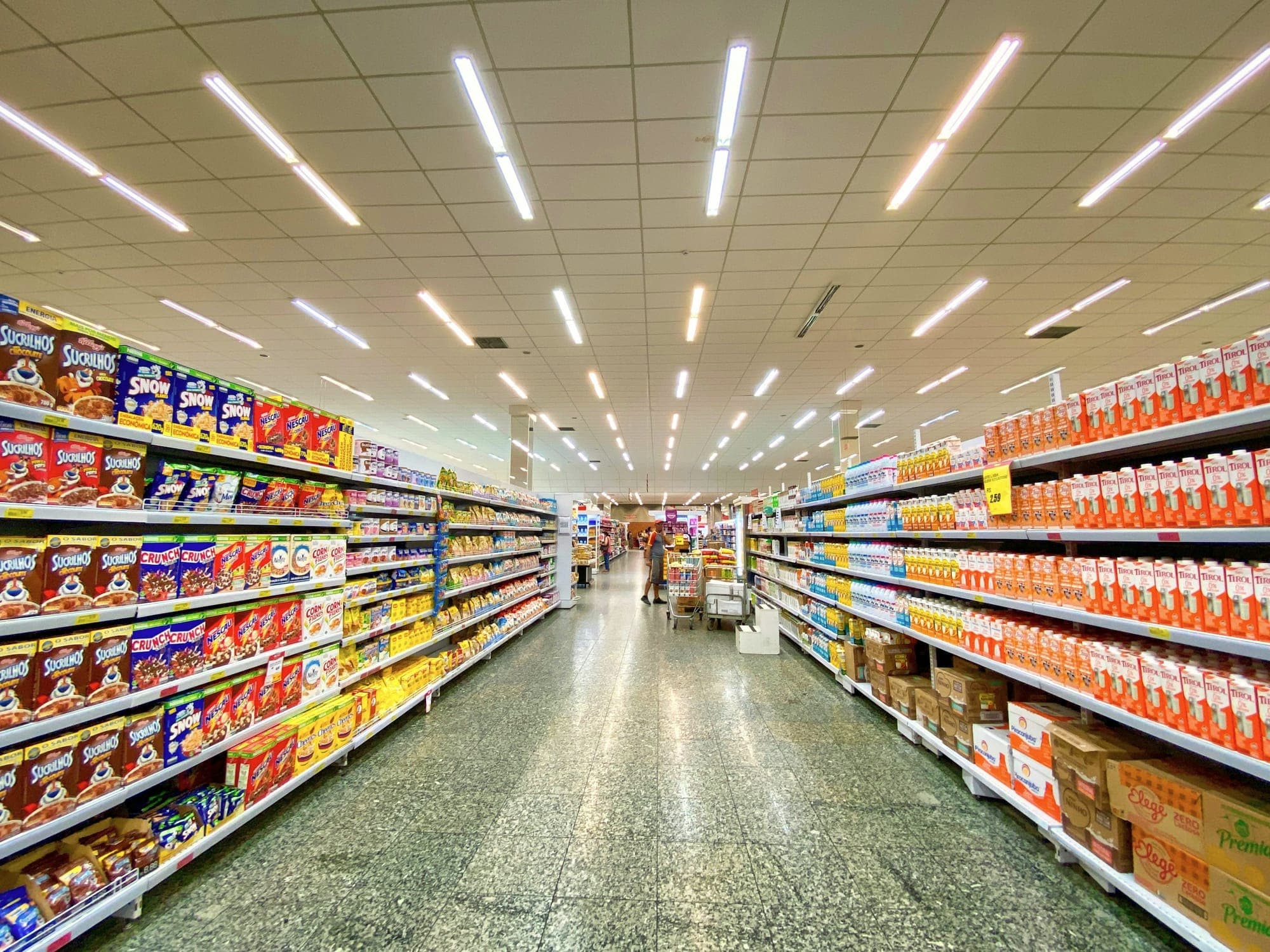 A supermarket aisle with stocked shelves on both sides