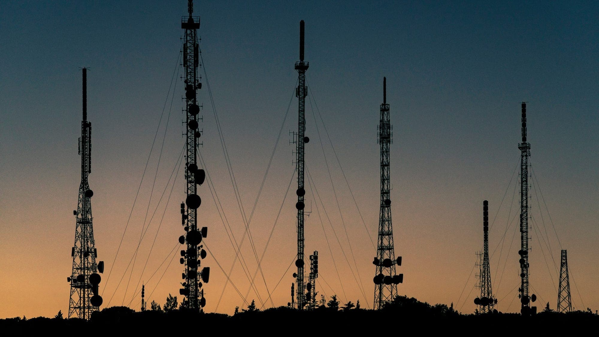Telecommunication towers against the evening sky